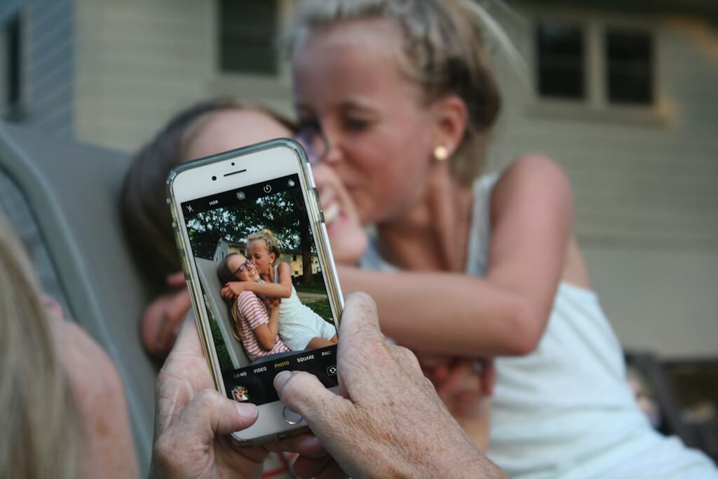 Mother and child taking picture and sharing it on a phone